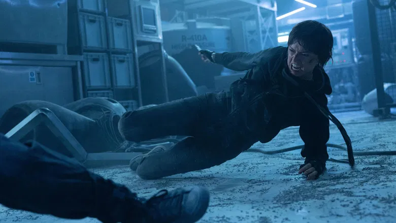 Clive Owen holding a gun in a suit